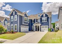 Beautiful blue two-story home with three-car garage and manicured lawn at 14925 Baldridge Dr, Huntersville, NC 28078