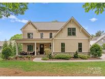 Charming two-story home with a welcoming front porch, landscaped yard, and a stone-accented foundation at 20614 Pointe Regatta Dr, Cornelius, NC 28031