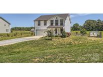 Charming two-story home features a well-manicured lawn and attached garage at 2206 Mills Harris Rd, Wingate, NC 28174