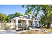 Charming home with stone accents, covered porch, gray shingles and wood columns at 415 Lakewood Ave, Charlotte, NC 28208