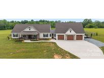 Charming home featuring a stone and white exterior, inviting front porch, and a spacious three-car garage at 4316 Nesbit Rd, Monroe, NC 28112