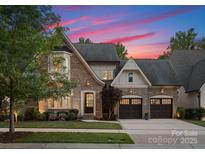 Charming brick home featuring a three-car garage, manicured lawn, and professional landscaping under a beautiful sky at 4635 Harper Ct, Charlotte, NC 28210