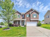 Charming two-story home featuring brick and wood accents, complemented by a well-manicured lawn and a two-car garage at 5146 Elementary View Dr, Charlotte, NC 28269