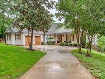 Charming home features a two-car garage, lush lawn, and inviting front porch with wooden columns and cozy seating at 5951 Johnson Rd, Clover, SC 29710