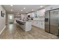 Bright kitchen with white cabinetry, stainless appliances, and a large center island with seating at 703 S Main St, Landis, NC 28088