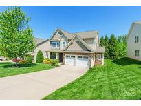 Charming two-story home with stone accents, attached two-car garage, and manicured lawn at 924 Forbes Rd, Fort Mill, SC 29707