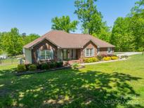 Charming brick home with a well-manicured lawn and colorful landscaping at 1005 Spring Rock Dr, Salisbury, NC 28146