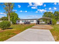 Charming single-story home with ample parking, canopy, and manicured lawn under a bright, sunny sky at 114 Doubletree Dr, Statesville, NC 28677