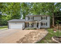 Charming two-story home with a covered front porch, an attached garage, and a well-manicured lawn at 130 Cherokee Ln, Salisbury, NC 28147