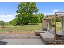 Inviting outdoor patio featuring a shaded seating area and expansive lawn, perfect for relaxation at 176 Jennymarie Rd, Mooresville, NC 28115