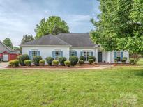 Charming one-story home with blue shutters, manicured landscaping, and a well-maintained lawn at 2603 Willis Dr, Harrisburg, NC 28075