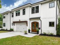 Elegant two-story home featuring white brick, dark window trim, and a beautifully landscaped front yard at 3505 Trent St, Charlotte, NC 28209