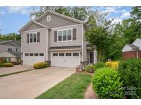 Charming exterior of a two-story home with a two-car garage and well-manicured landscaping at 5210 Valley Stream Rd, Charlotte, NC 28209