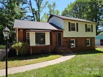 Charming two-story home featuring brick and vinyl siding, with a well-maintained front lawn and mature trees at 6212 Snowcrest Ct, Charlotte, NC 28212