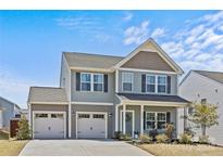Charming two-story home with a two-car garage, gray siding, and a well-manicured lawn on a sunny day at 1062 River Haven Sw Ave, Concord, NC 28025