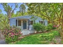 Charming blue home featuring a quaint porch, a well-manicured lawn, and blooming azalea bushes at 1104 Norris Ave, Charlotte, NC 28206