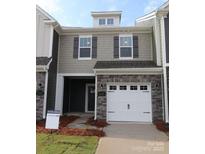 Charming townhouse with stone accents, a one-car garage, and a well-maintained lawn at 1115 Overbrook Pl, Wingate, NC 28174