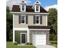 Charming two-story home featuring a mix of vertical siding and brick accents with a two car garage at 1137 Overbrook Pl, Wingate, NC 28174