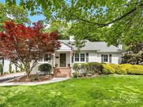 Charming white brick home with a landscaped front yard, brick steps, and an inviting bench at 1209 Yale Pl, Charlotte, NC 28209