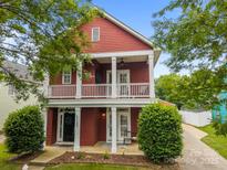 Charming two-story home with a double balcony and red siding at 1508 Peaceful Way Dr, Charlotte, NC 28206