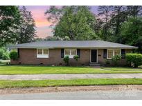Brick home with black shutters, green lawn, and sidewalk leading to the front door at 1532 Downs Ave, Charlotte, NC 28205