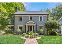 Charming two-story home with a well-manicured lawn, brick walkway, and lush landscaping at 1726 The Plz, Charlotte, NC 28205