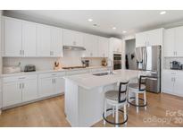 Bright, modern kitchen with white cabinets, stainless steel appliances, and a breakfast bar at 190 Tetcott St, Mooresville, NC 28115