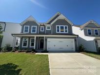 Charming two-story home with a well-manicured lawn, inviting front porch, and two-car garage for modern suburban living at 2012 Embassy Ct # 46, Charlotte, NC 28213