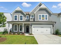 Charming two-story home with gray siding, white trim, a two-car garage, and a well-manicured lawn at 2012 Embassy Ct # 46, Charlotte, NC 28213