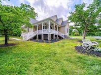 Charming home featuring a large porch, decorative landscaping, and a lush green lawn at 206 Montclair Dr, Locust, NC 28097