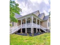 Inviting home featuring a charming front porch with classic railings and stone accents at 206 Montclair Dr, Locust, NC 28097