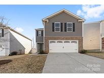 Charming two-story home featuring gray siding, brick accents, a two-car garage, and well-maintained landscaping at 2120 Redstone Dr, York, SC 29745