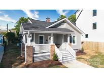 Charming gray two-story home featuring brick accents, freshly mulched landscaping, and a welcoming front porch at 2124 Roslyn Ave, Charlotte, NC 28208