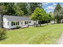 Charming single-story home featuring a well-maintained lawn, modern exterior, and a welcoming front porch at 221 Belton Ave, Mount Holly, NC 28120