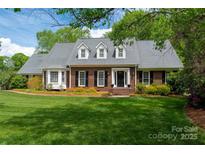Charming brick home boasts a lush, green lawn and well-maintained landscaping under a bright, sunny sky at 2382 Erika Ln, Gastonia, NC 28056