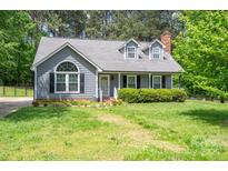Charming gray home with a well-manicured lawn and inviting front porch and trimmed shrubbery at 2439 Caswell Ct, Gastonia, NC 28054
