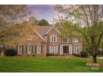 Beautiful brick home with a well-manicured lawn and mature trees in a desirable neighborhood at 4027 Wallbrook Dr, Matthews, NC 28105