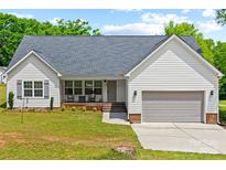 Charming single Gathering home with a well manicured front lawn, driveway, and integrated garage at 1009 Rainbow Cir, Catawba, SC 29704