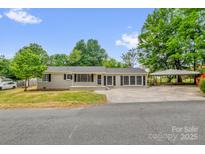 Charming single-story home with neutral paint, dark shutters, well-maintained lawn and convenient covered parking at 105 N Baldwin Ave, Kannapolis, NC 28083