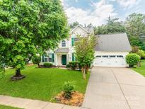Charming two-story home with white siding, green shutters, well-manicured lawn, and a two-car garage at 11719 Withers Mill Dr, Charlotte, NC 28278