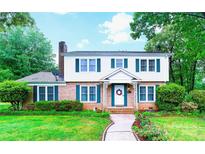 Charming two-story home featuring a brick facade, white siding, green shutters, and a neatly landscaped front yard at 1287 Queensgate St, Gastonia, NC 28054