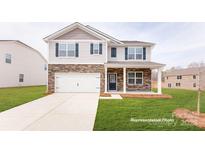 Charming two-story home with stone accents, a garage, a well-manicured lawn, and a welcoming front porch at 1356 Secrest Commons Dr, Monroe, NC 28112