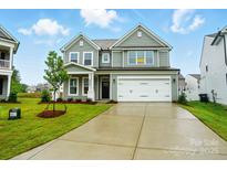 Charming two-story home featuring a two-car garage, manicured lawn, and classic architectural details at 2020 Embassy Ct # 48, Charlotte, NC 28213