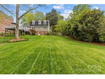 Expansive backyard with lush lawn and mature trees, perfect for outdoor activities and relaxation at 2418 Ainsdale Rd, Charlotte, NC 28226