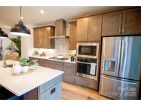 Modern kitchen with stainless steel appliances, quartz counters, and stylish cabinetry, offering a blend of functionality and design at 313 Old Town Village Rd, Waxhaw, NC 28173