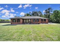 Well-maintained brick ranch-style home with a lush green lawn and mature trees at 3270 Kings Row Dr, Rock Hill, SC 29732