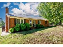 Charming single story red brick home featuring mature trees, shutters, and an inviting front entrance at 3842 Harmony Rd, Catawba, SC 29704