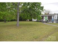 Charming single-story home with a well-maintained lawn and mature trees, creating a serene setting at 4671 Lucas Ct, Harrisburg, NC 28075