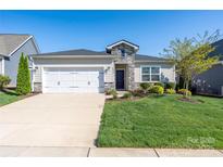 Charming single-story home featuring stone accents, a well-manicured lawn, and a two-car garage at 6272 Raven Rock Dr, Denver, NC 28037