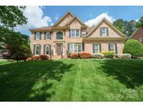 Beautiful two-story brick home with a well-manicured lawn, mature landscaping, and a welcoming front entrance at 10101 Bayart Way, Huntersville, NC 28078